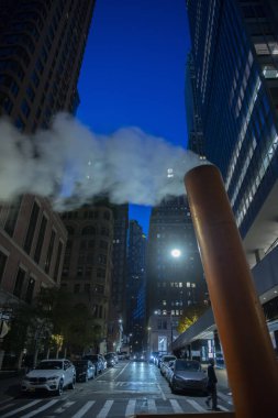 Manhattan, New York, ABD 'de soğuk bir gecede bir buhar borusunun dikey görüntüsü.
