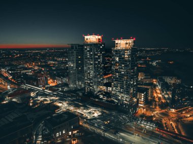 Yoğun şehir manzarasının hava görüntüsü akşam geç saatlerde çekilen rengarenk günbatımı gökyüzüne karşı.