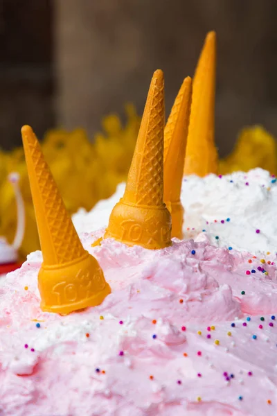 ピンク色のアイスクリームの風味とカラフルなスプリンクルの茶色のコーンのクローズアップ — ストック写真