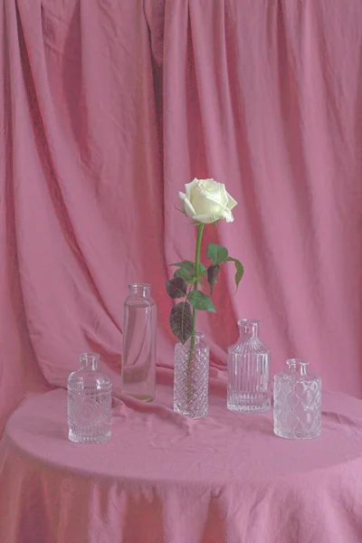 Colpo Verticale Rose Bianche Con Belle Bottiglie Vetro Una Superficie — Foto Stock