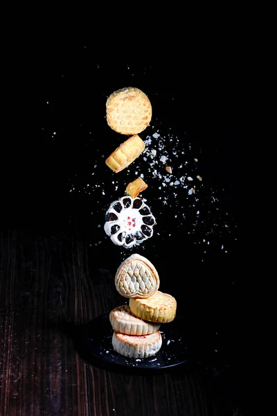 黒い背景に浮かぶクッキーの垂直ショット — ストック写真