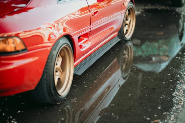 Крупный План Нижней Части Красного Автомобиля Отражение Мокрой Земле — стоковое фото