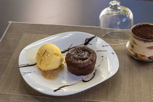 Egy Csokis Pite Vaníliás Jégkrémmel Fehér Tálcán Tálalva Asztalon — Stock Fotó