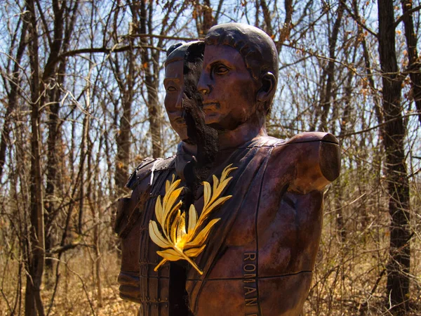 A closeup shot of a bronze sculpture of a man cut in half at the Overland Park Arboretum, Kansas, USA