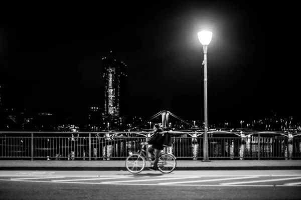 Der Radler Der Nachts Auf Der Brücke Fährt Hintergrund Die — Stockfoto