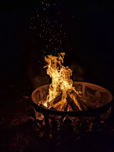 黒い背景の上のたき火の垂直ショット — ストック写真