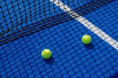 Mavi raket tenis kortunun gölgesinde iki raket tenis topu, raket spor konsepti