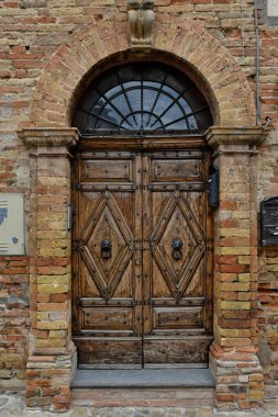 İtalya 'nın Marche bölgesinde eski bir kasaba olan Montecosaro' daki bir ortaçağ evinin ön kapısının dikey görüntüsü..