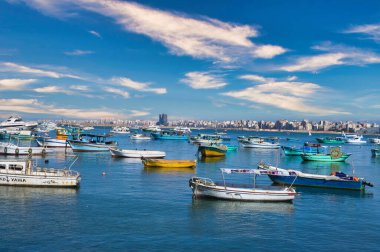 Mısır 'da, Kızıl Deniz kıyısındaki Alex Sea platformunda parlak bulutlu gökyüzünün altında birkaç küçük tekne var.