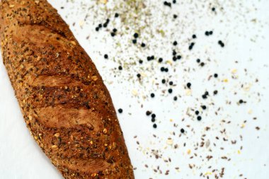 Beyaz bir masada otlar ve baharatlarla tatlandırılmış bir ekmek rulosu