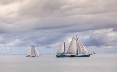 Markermeer Gölü 'nde gündüz vakti bulutlu gökyüzüne, Volendam' a ve Hollanda 'ya yelken açan güzel bir yelkenli çekimi.
