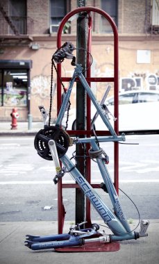 Tekerlekleri olmayan bir direğe kilitlenmiş bisiklet.