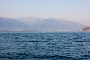 Arka planda kayalık dağlar olan nefes kesici bir deniz manzarası.