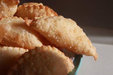 Bir kase içinde lezzetli pofuduk samosa hamur tatlısı.