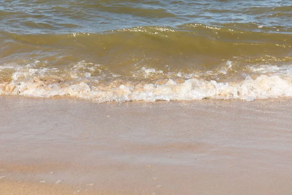 晴れた日に砂浜に波が打ち寄せる — ストック写真