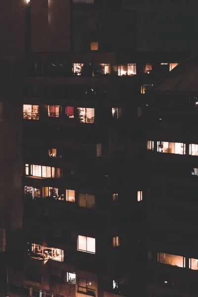 Pionowe Ujęcie Budynku Nocy Kilkoma Oświetlonymi Oknami — Zdjęcie stockowe