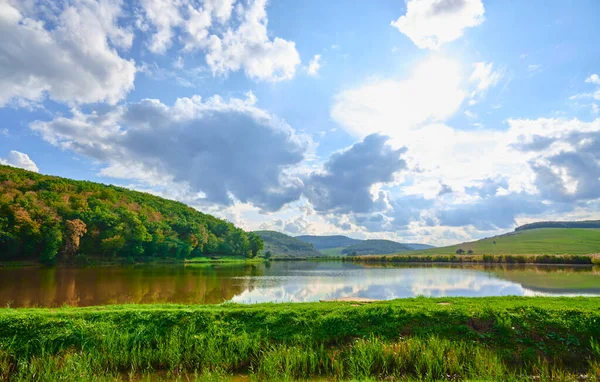 Romanya 'nın Cluj kentinde yeşil kırsal manzaranın üzerinde parlak güneşli bir gökyüzü