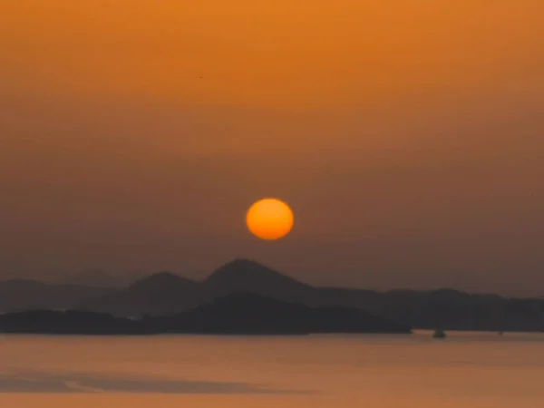 Une Silhouette Collines Travers Eau Coucher Soleil — Photo