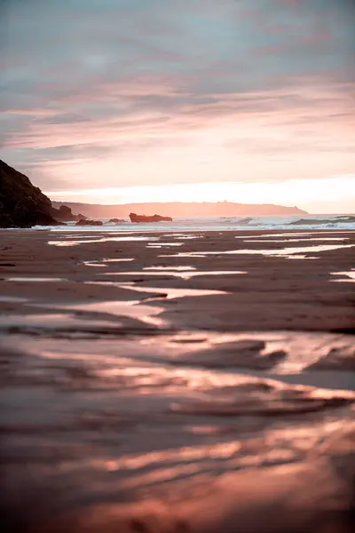 Eine Vertikale Aufnahme Eines Leuchtend Rosa Sonnenuntergangs Über Einem Strand — Stockfoto