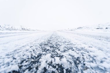 Düşük açılı, karlı kırsal bir yolun gözden kaybolma noktası.