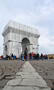 Arc de Triomphe 'nin dikey çekimi, kalabalıkla, gümüş mavisi kumaş ve kırmızı iple sarılı.
