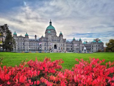 The Building of Legislative Assembly in autumn with big garden and flowers in downtown Victoria, BC, Canada clipart