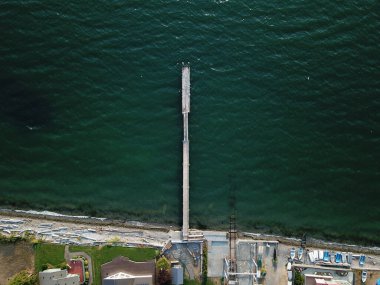 Ortasında ince ahşap bir iskelesi olan güzel koyu yeşil okyanusu kuş bakışı görmek.