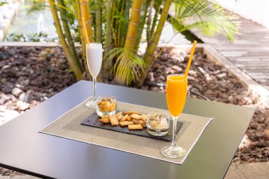 Meyve suyu dolu bir masada servis edilen bir tabak dondurmalı ve çıtır çıtır kurabiye.