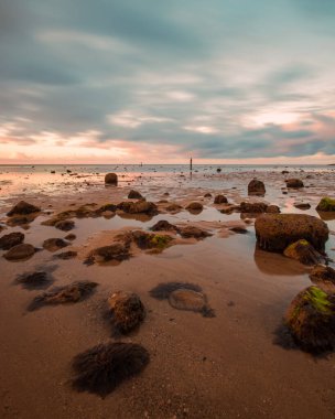 Gün batımında kayalık kumlu bir sahil
