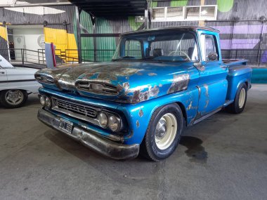 Eski mavi Chevrolet Chevy C10 Apaçi kamyoneti 1960-1961 yılları arasında bir depoda park halindeydi. Alet edevat mı, tarım aleti mi? Klasik araba şovu. Kopyalama alanı