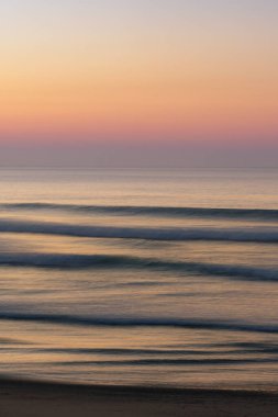 Gün batımında kumsalda güzel bir deniz dalgası manzarası.