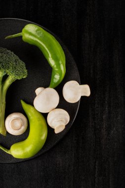 Siyah tabakta mantarlı, dikey brokoli.