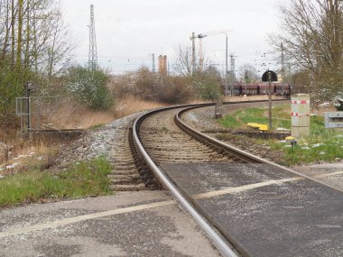 Ağaçlarla çevrili kıvrımlı tren rayları olan boş bir demiryolu.