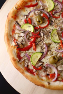 Domatesli iştah açıcı pizza, dilimlenmiş balkabağı yeşil zeytin ve ahşap tepside peynirli soğan.