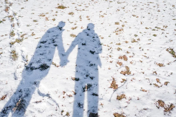 一对恋人牵着手走在雪地上的影子 浪漫的概念 — 图库照片