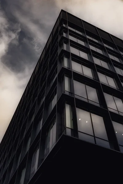 Vinkellös Bild Modern Kontorsbyggnad Med Skarpa Kanter Den Molniga Himlen — Stockfoto