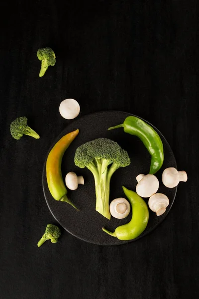 Een Verticaal Shot Broccoli Met Champignons Een Zwarte Plaat — Stockfoto