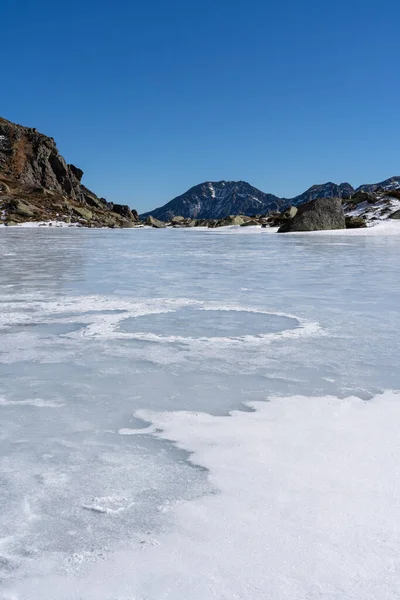 青い空に対して晴れた日に冬の間に凍った湖の垂直閉鎖ショット — ストック写真