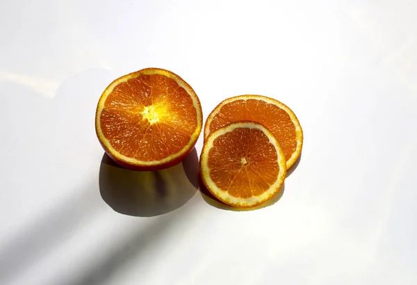 葉の影を持つ白い背景に熟したジューシーなオレンジのスライスの閉鎖 — ストック写真