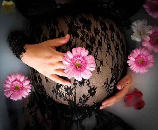 Çiçeklerle Çevrili Siyah Dantelli Bir Elbiseyle Karnını Tutan Hamile Bir — Stok fotoğraf
