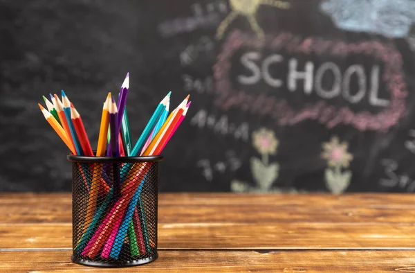 Closeup Shot Colored Pencils Mesh Pencils Holder Wooden Table Chalkboard — Stock Photo, Image