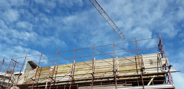 Een Hoge Kraan Een Bouwplaats Onder Een Wispy Lucht — Stockfoto