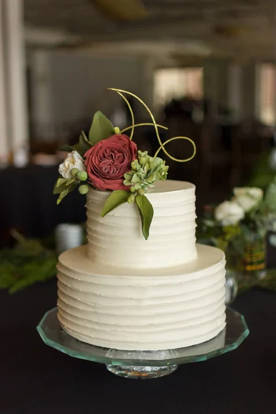 一个带有可食用玫瑰花束的两层松饼婚礼蛋糕的垂直特写镜头 — 图库照片