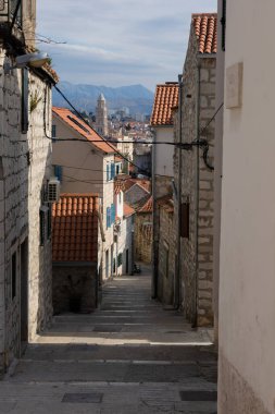 Geleneksel Avrupa evlerinden geçen ince bir caddenin manzaralı bir görüntüsü.