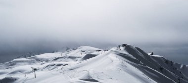 Karla kaplı güzel dağların panoramik görüntüsü.