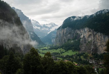 Kayalık arazilerin ve baharda yeşil tarlaların üzerindeki bulutlu mavi gökyüzü