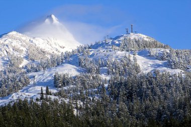 Kışın yüksek dağlarda bir kayak alanı manzarası.