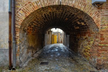 İtalya 'nın Marche bölgesindeki bir ortaçağ kasabası olan Montecosaro' nun eski evleri arasında dar bir yol var.