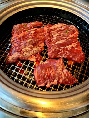 Izgarada pişen çiğ etin dikey çekimi.