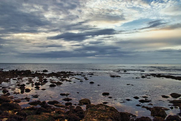 Vattensamling Nära Stenig Strand Den Molniga Himlen — Stockfoto